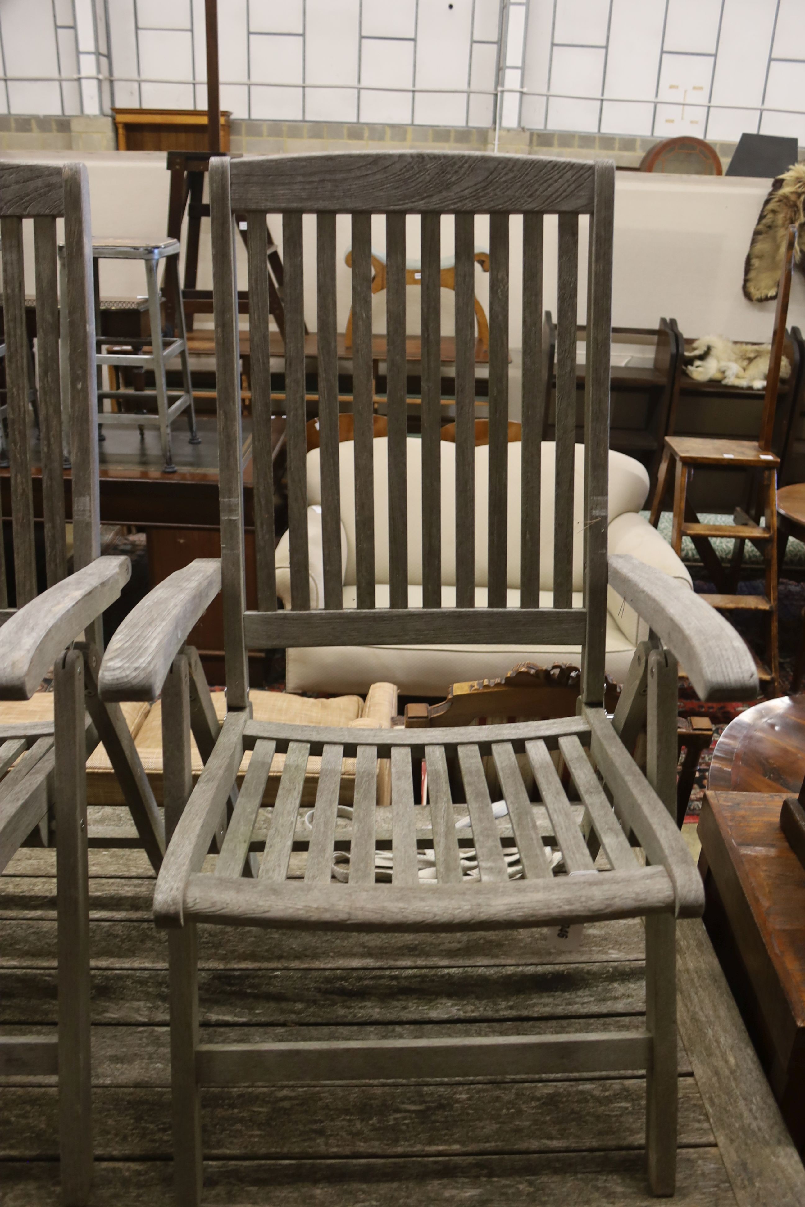 A suite of furniture comprising a weathered teak garden table, length 290cm, depth 90cm, height 74cm, and a set of eight Neptune teak folding garden armchairs